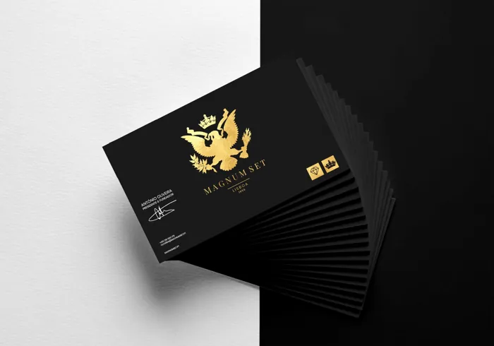 A fan of black Magnum Set business cards with a gold foil crest